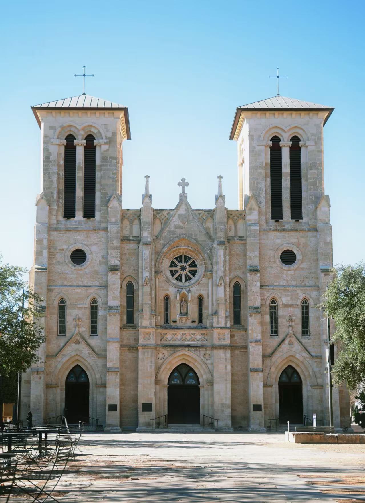 Stone building facade with two towers beneath a blue sky