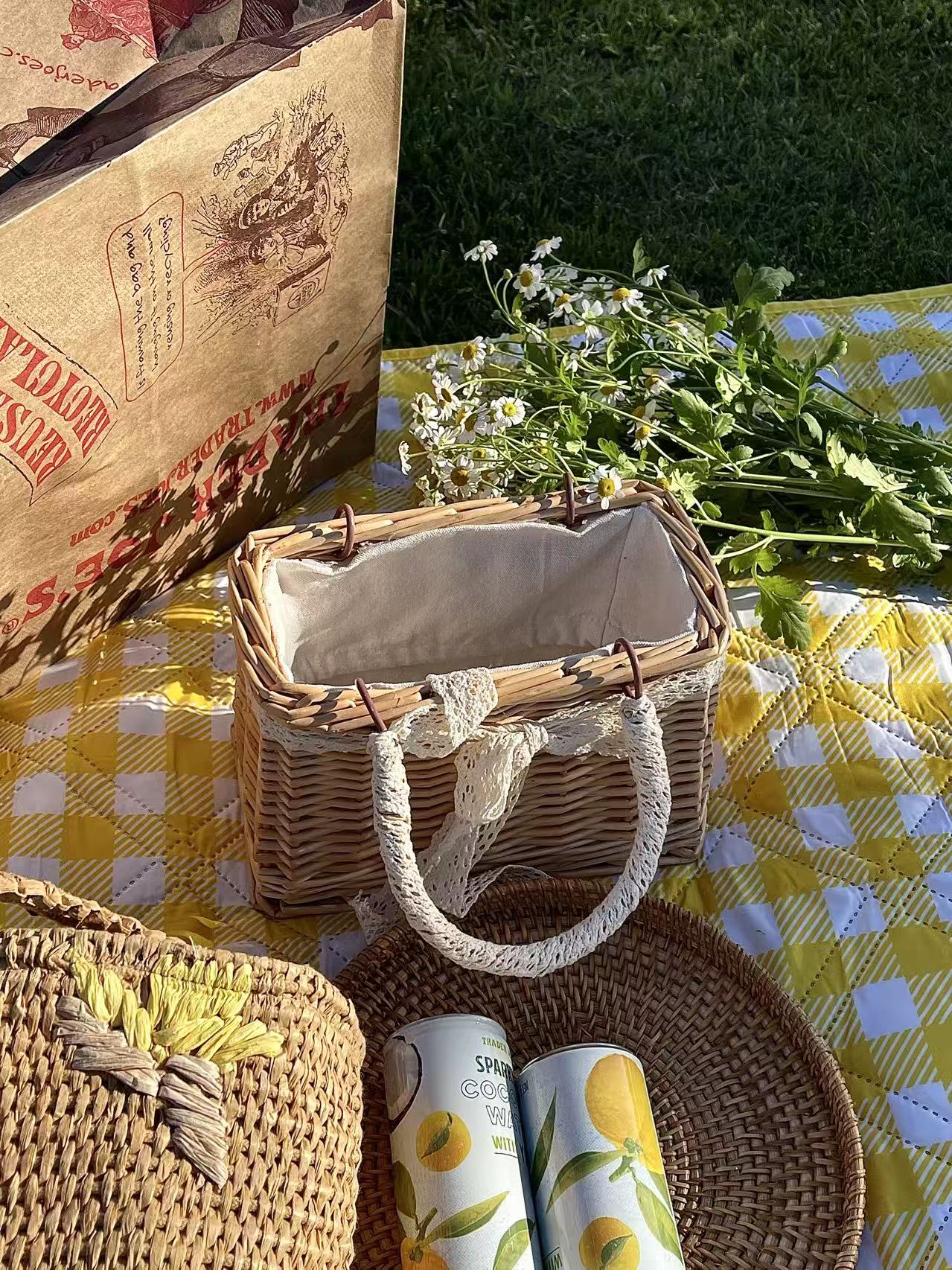 Wicker picnic baskets, daisies and lemon drinks on a yellow checked cloth
